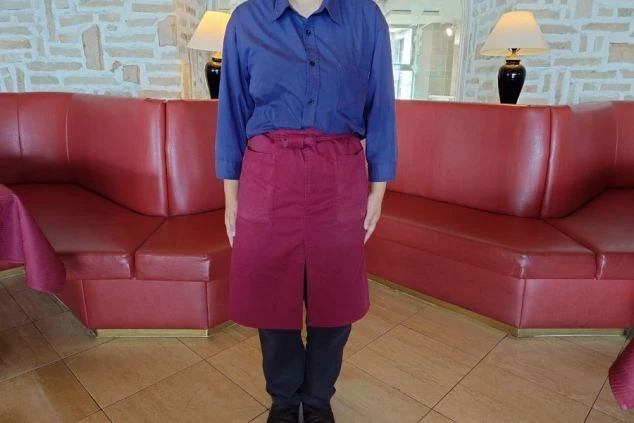レストランで働く女性の制服。青いシャツに赤のサロンを巻いたスタイル。