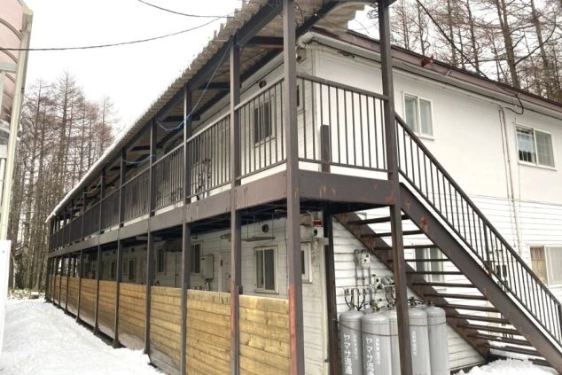 雪が積もった冬の季節のリゾートバイト寮の外観。アパートタイプの建物で、住み込み生活の雰囲気が伝わる寮画像。