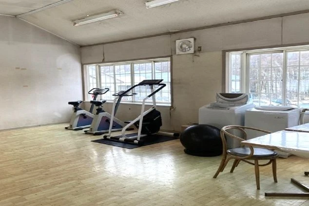 リゾートバイト寮の共用スペース。洗濯機やトレーニング用の自転車が置かれ、仕事の後にリフレッシュできる設備の画像。