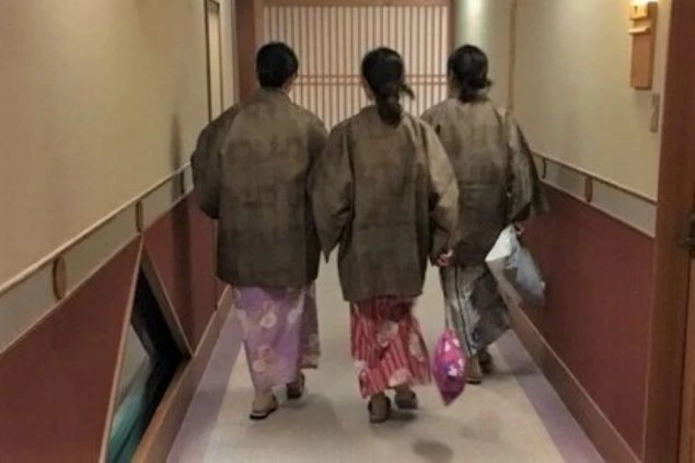 大きな石積みの柱と壁が特徴的で、木目調の玄関扉と、緑色の屋根の庇がある。上部は白壁に木の梁がデザインされた洋風の構造になっている。