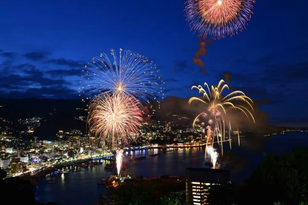  静岡県熱海の海上で打ち上がる花火大会。温泉街の夜景を彩る壮大な花火。リゾートバイトの休日に楽しめるイベント。