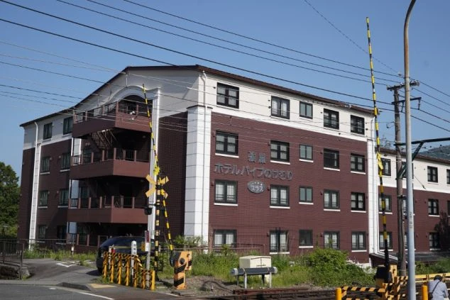 ホテルやレストランで働く女性スタッフ。トレイに水を乗せて運ぶホールスタッフの仕事風景。接客やサービス業のリゾートバイト。