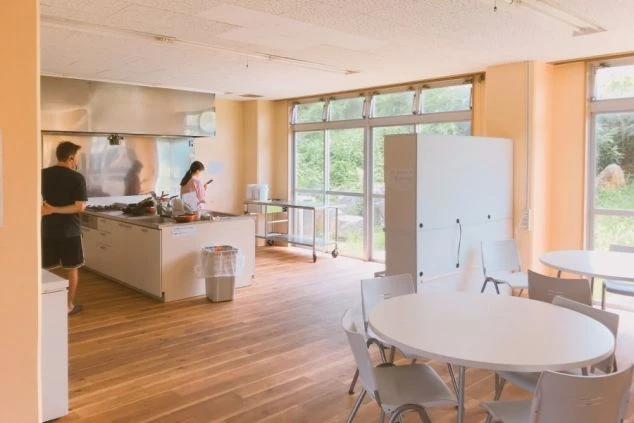 沖縄でリゾートバイトをするスタッフが住む寮の共用部の画像。キッチンやテーブルがある。