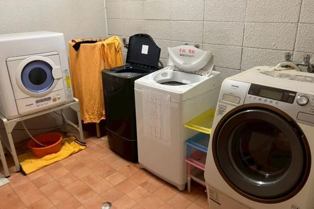 リゾートバイト寮の共用ランドリースペースの画像。洗濯機と乾燥機が設置されており、生活しやすい寮環境をアピール。