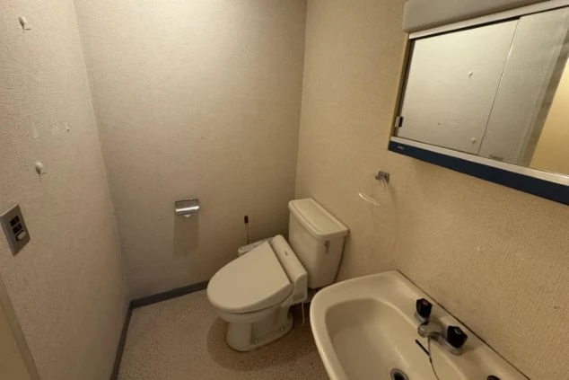 寮のトイレと洗面台。温水洗浄便座付きのトイレと、鏡付きの洗面台がコンパクトに一体化されている。