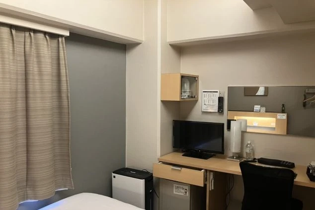 リゾートバイトの寮(客室タイプ)の室内。ホテルの客室のようなプライベート空間で、ベッド、机、テレビ、空気清浄機などが完備されています。