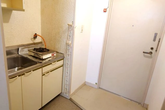 玄関を入ってすぐの場所に設置された、一口コンロとシンク付きのコンパクトなキッチン。