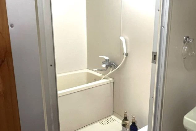 客室寮に備え付けのユニットバスの画像。清潔な浴槽とシャワーがあり、部屋内で入浴できるので便利。