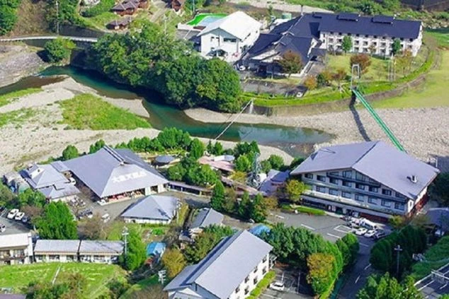 清流沿いにあるリゾートバイト先の温泉旅館やホテル群の全景画像。
