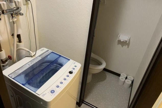 個室内に設置された全自動洗濯機の画像。共有スペースに行かず自室で洗濯ができる。