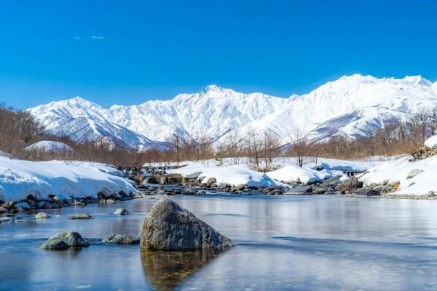 長野県 白馬の雪景色。雪をかぶった山々と清流。冬のリゾートバイトの絶景。