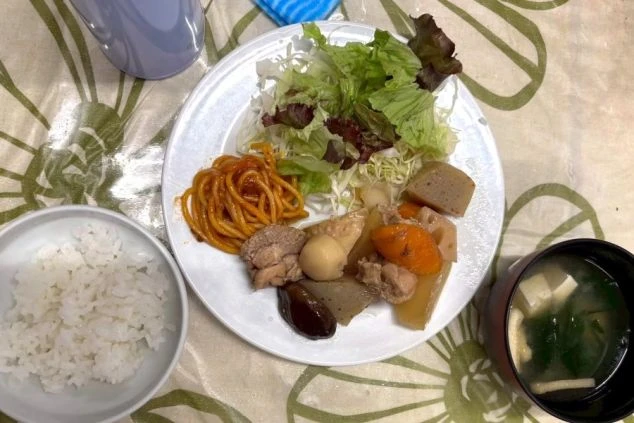 サラダ、みそ汁、白米、揚げ物、副菜とバランスの良いリゾートバイトのまかない画像。