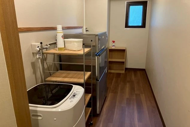 兵庫県の旅館でのリゾートバイトの寮内の画像。洗濯機や棚や電子レンジがある。