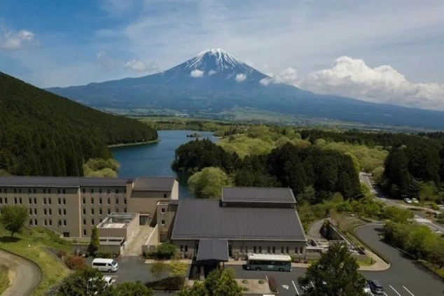 湖畔に建つホテルと、その背後にそびえ立つ雄大な富士山。