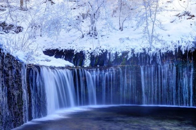 雪化粧を纏い、氷柱が垂れ下がる幻想的な冬の軽井沢・白糸の滝。