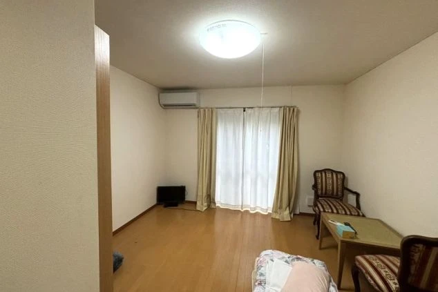 リゾートバイトの完全個室寮の室内。エアコンや家具家電付きの広々としたフローリング洋室。
