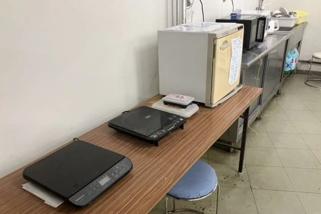 リゾートバイト寮の共用キッチンの画像。自炊ができるIHヒーターや電子レンジなど調理設備が充実。