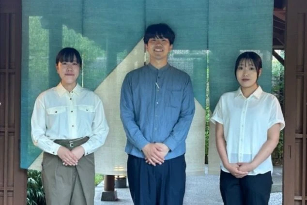 淡い色合いの制服を着用した男女3名の従業員。中央の男性を挟んで両脇に女性が立ち、穏やかな表情で写る集合写真。