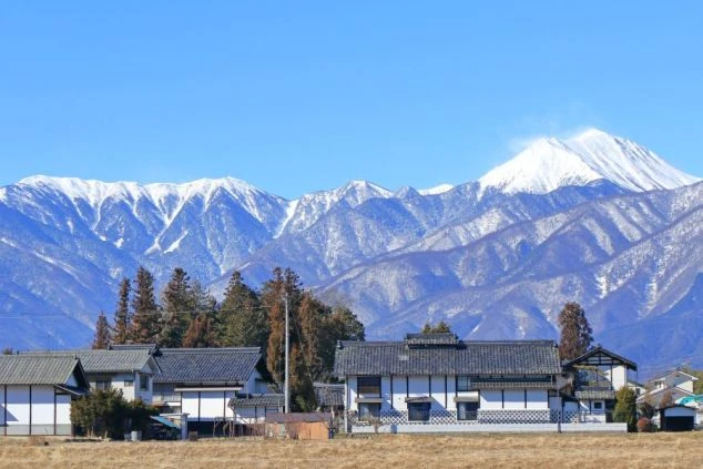 雪化粧をした雄大な山々と日本の家並み。リゾートバイトは美しい絶景を毎日見られます。