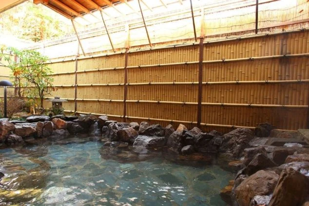 竹垣と岩に囲まれた趣ある露天風呂。リゾートバイトは、仕事の後に温泉で疲れを癒せます。