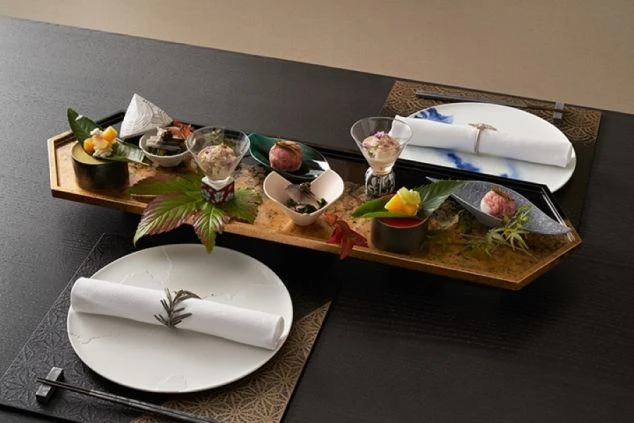 黒いテーブルの上に置かれた、美しく盛り付けられた和食の前菜。