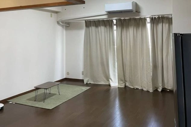 明るく現代的な部屋の屋内ショットでその奥には大きな窓があり、そこから自然光が差し込み、床に明るい光の筋を作り出しています。