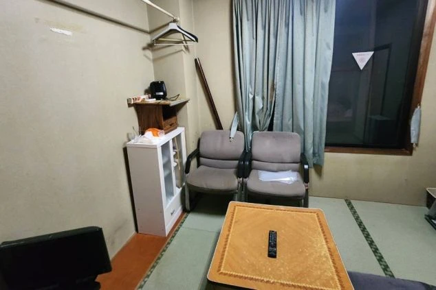 テレビ、冷蔵庫、ソファ、ヒーターが完備されたリゾートバイト寮の個室画像。