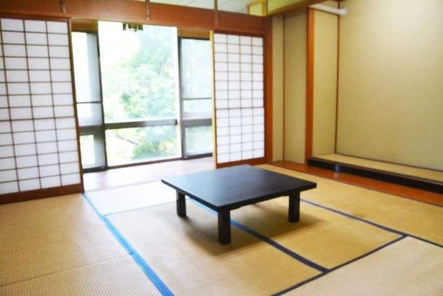 リゾートバイトの男性寮の個室内。和室で落ち着いた雰囲気。