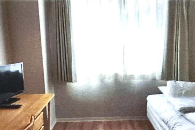 リゾートバイトの社員寮の部屋を表現するイメージ画像。ベッドとテレビ、窓が備え付けられたシンプルな個室。