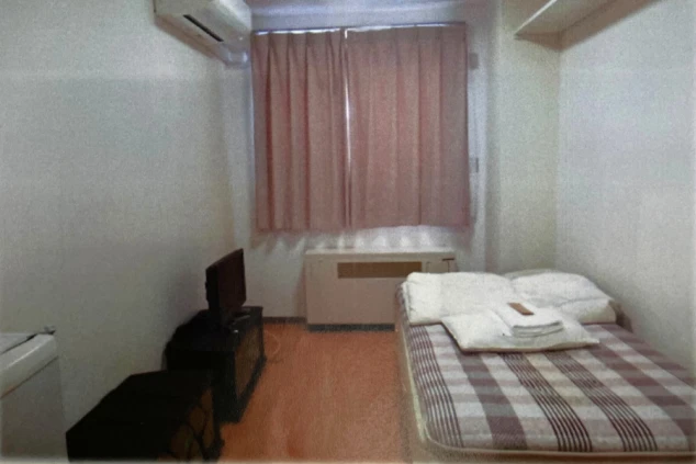 リゾートバイトの社員寮の部屋を表現するイメージ画像。ベッドやテレビ、エアコンが備え付けられたシンプルな個室。