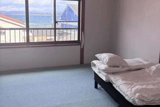 和歌山・白浜のリゾートバイト個室寮。窓から海を望むオーシャンビューの室内で、快適な住み込み生活。