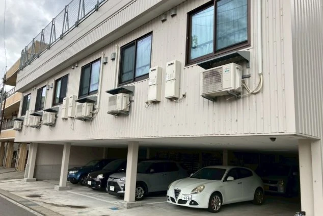 リゾートバイトの寮の外観の画像。1階部分は駐車場になっており、2階には部屋が並んでいる。リゾートバイトの寮の外観の画像。