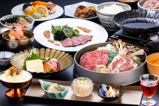 霜降りの和牛や新鮮なお造り、彩り豊かな小鉢が並ぶ豪華な和食会席膳の画像。