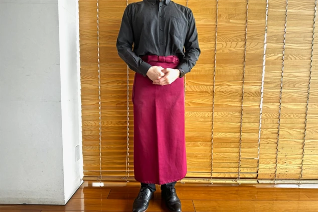 リゾートバイトの仕事風景のイメージ画像。レストランのホールの仕事で着用する、黒いシャツとエンジ色のエプロン。