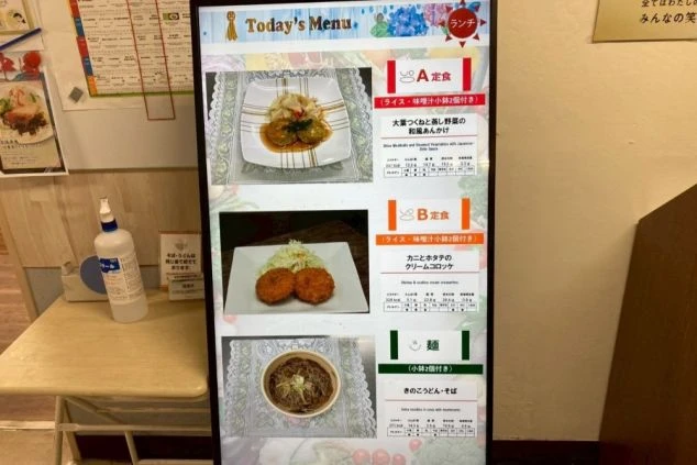 A定食、B定食、麺類が写真付きで表示された、本日のランチ献立ボード。