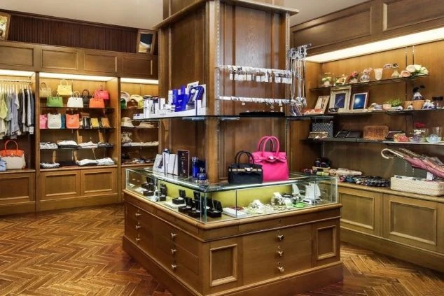 木製の高級感ある内装のブティック。中央のガラスケースにアクセサリーなどが陳列されている。