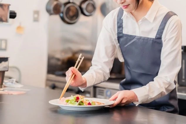 リゾートバイトのレストラン業務。未経験でも安心の盛り付けや調理補助を行うキッチンスタッフの様子。