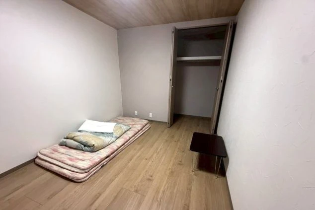 リゾートバイト完全個室寮の室内。収納クローゼット付きの綺麗なフローリング洋室で、快適な住み込み生活が可能。