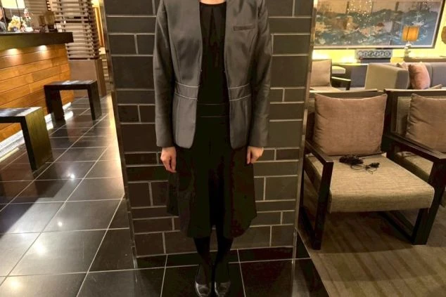 就業先ホテルのフロントスタッフの制服。黒のインナーにスカート、グレーのジャケットスタイル。