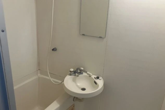 リゾートバイトの寮のユニットバス。シャワー付きの浴槽と洗面台が一体になった清潔な浴室。