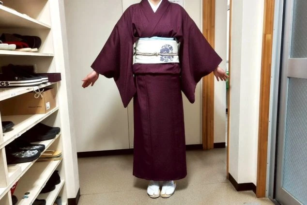 旅館の制服であるベージュ色の着物を着用した女性スタッフ