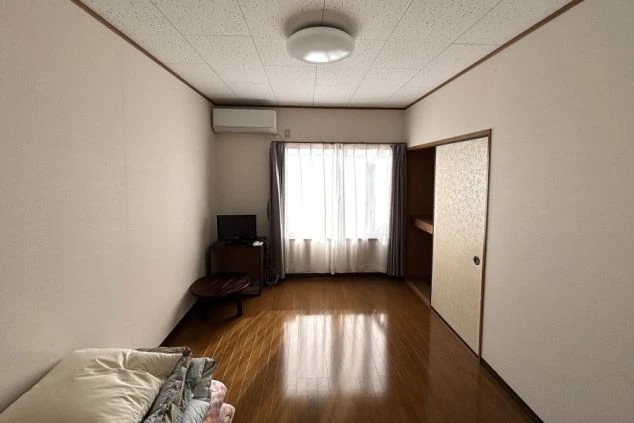 リゾートバイトの個室寮の部屋の画像。部屋にはベッドとテレビ、そして窓がある。窓からは光が差し込み、明るい雰囲気の部屋であることがわかる。