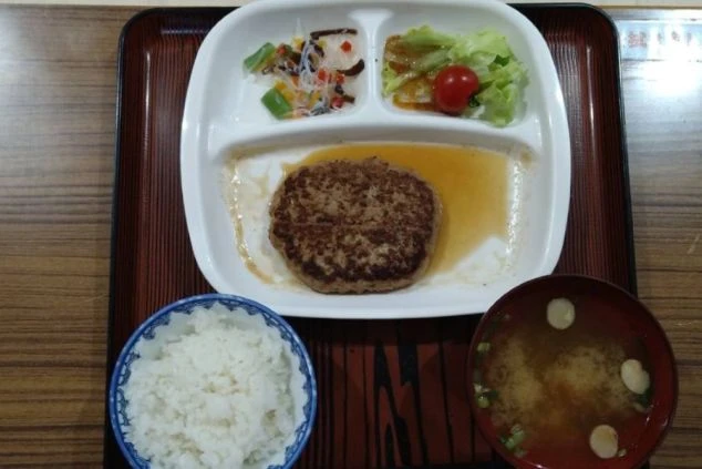 リゾートバイトのまかない。ハンバーグをメインに、ご飯、お味噌汁、副菜が付いた栄養バランスの良い定食。