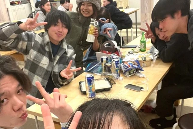 ダイニングテーブルで楽しそうにピースサインをするリゾートバイトの仲間たち。仕事終わりの交流や休日のイメージ。