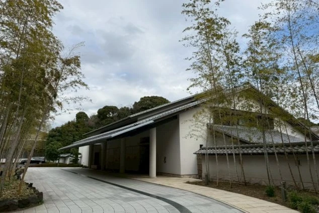 竹林に囲まれた、瓦屋根の和風建築の入り口。