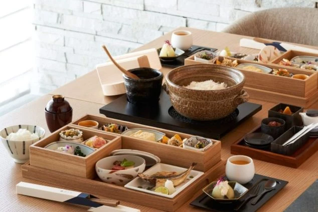 施設で提供する和食の朝食の画像。土鍋で炊かれたご飯にたくさんのおかず。