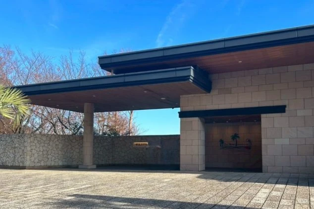 石造りの壁と、大きな庇（ひさし）を持つ車寄せ（エントランス）が見える。