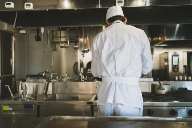 ホテルの厨房で調理服を着た人物。調理補助のリゾートバイト求人。