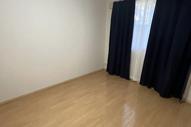 明るい木目調のフローリングが特徴の個室寮。エアコンや遮光カーテンが完備された、リフレッシュに最適なプライベート空間。