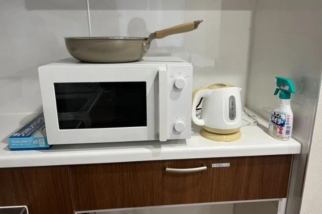 寮の共用キッチンにある電子レンジと電気ケトル。リゾートバイトの休憩時間に自炊や調理ができる設備。